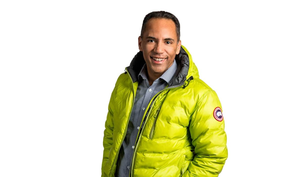 Tim Hauge smiling at the camera, wearing a bright green puffer jacket.