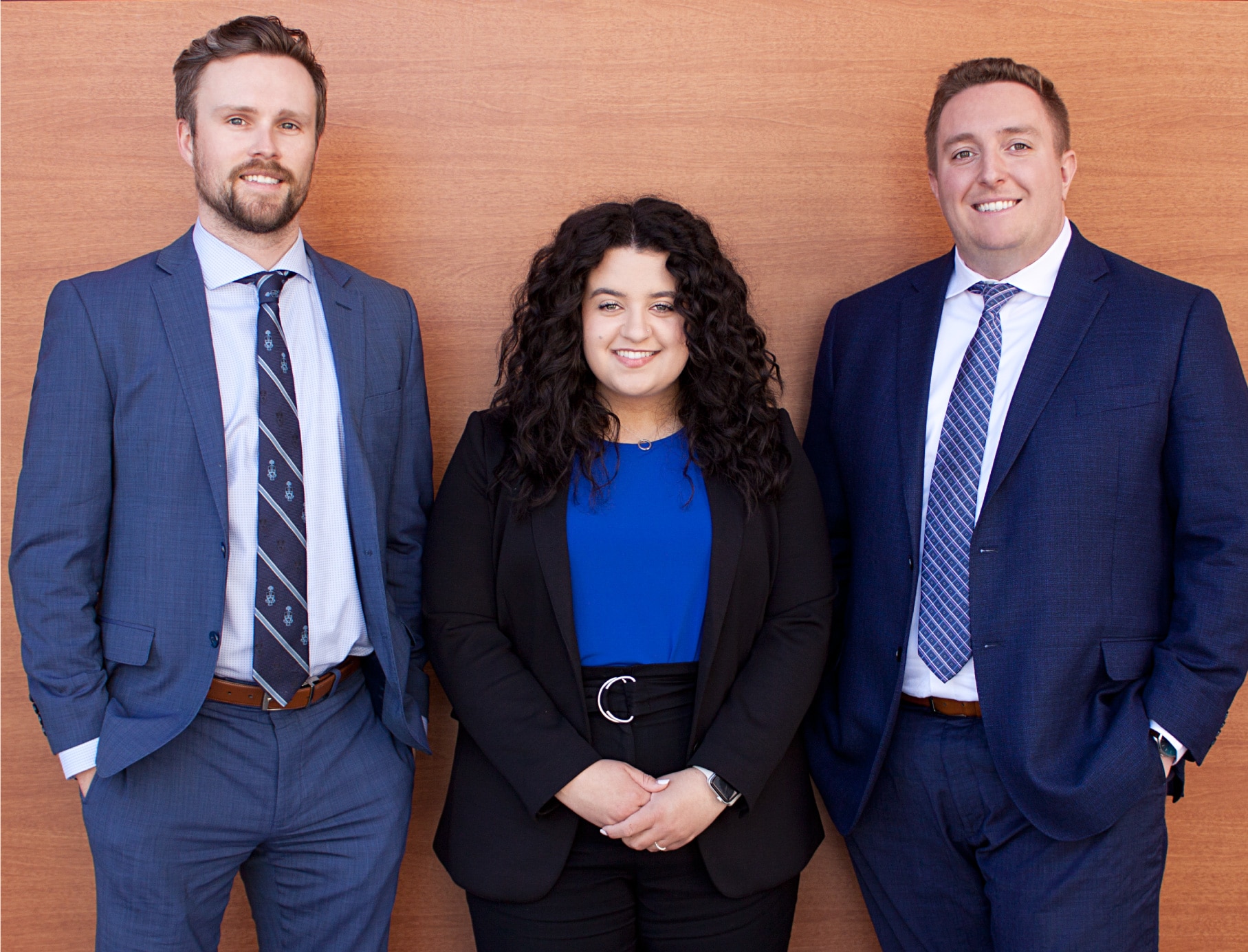 Three associates in professional attire, smiling at the camera.
